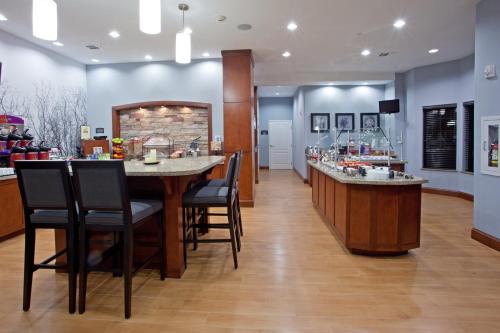 a bar in a restaurant with chairs and a counter at Staybridge Suites Houston Stafford - Sugar Land by IHG in Stafford