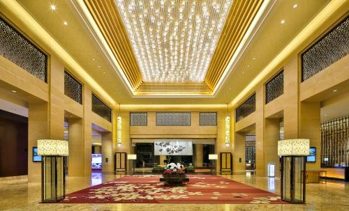 een lobby met een groot plafond en een kroonluchter bij Crowne Plaza Chengdu Panda Garden, an IHG Hotel in Chengdu