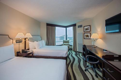 a hotel room with two beds and a large window at Fort Pontchartrain Detroit, a Wyndham Hotel in Detroit