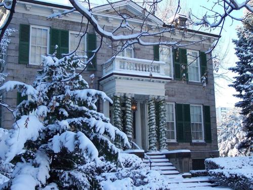 a snow covered tree in front of a house at Staybridge Suites Hamilton - Downtown by IHG in Hamilton