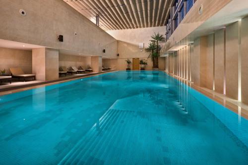 a large swimming pool with blue water in a building at Crowne Plaza Shanghai Noah Square, an IHG Hotel in Shanghai