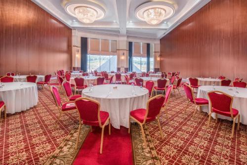 a banquet room with white tables and red chairs at Crowne Plaza Istanbul Asia by IHG in Istanbul