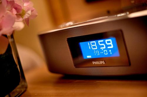 a clock sitting on top of a wooden table at Expo Center Hotel - Free Shuttle Bus & Late Check-out in Yiwu