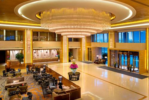 un vestíbulo de un hotel con una gran lámpara de araña en Expo Center Hotel, en Yiwu