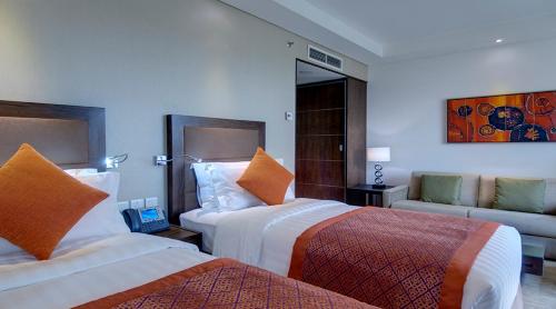 a hotel room with two beds and a couch at Crowne Plaza Madinah by IHG in Al Madinah