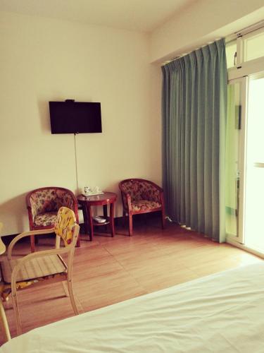 Una habitación con dos sillas y una mesa y un televisor. en 星海芝家民宿Samuel's Home, en Nangan