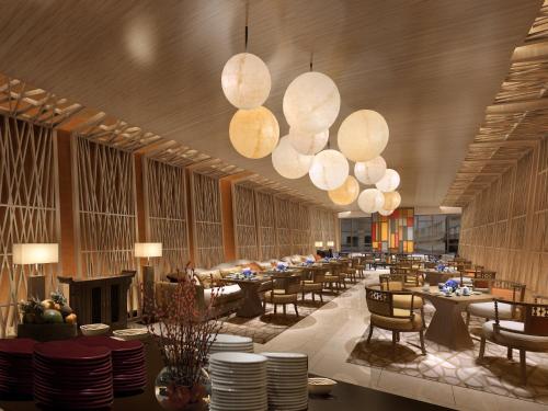 a dining room with tables and chairs and lights at Howard Johnson Neodalle Resort Zhangjiajie in Zhangjiajie