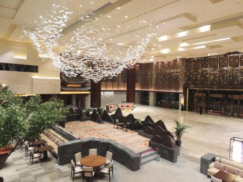 a large lobby with couches and tables and chandeliers at Howard Johnson Neodalle Resort Zhangjiajie in Zhangjiajie