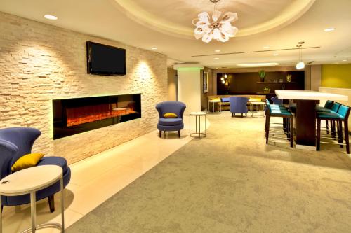 a lobby with a fireplace and chairs and a bar at Crowne Plaza Kitchener-Waterloo by IHG in Kitchener
