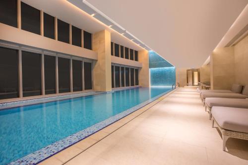 a swimming pool in a hotel with lounge chairs at Crowne Plaza Macau by IHG in Macau