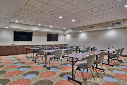 a conference room with tables and chairs and a screen at Staybridge Suites Lubbock South by IHG in Lubbock