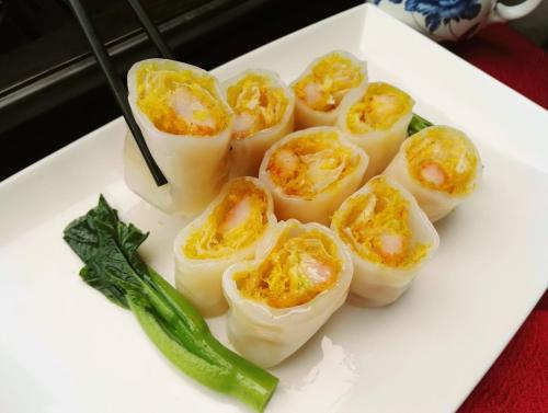 a white plate with deviled eggs and a green pepper at Junluxe Hotel Guangzhou Zengcheng-Free Shuttle Bus For Canton Fair in Zengcheng