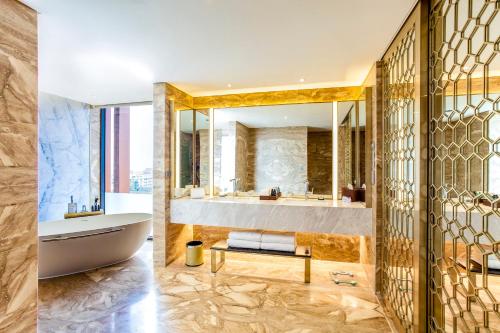 two images of a bathroom with a tub and a sink at Crowne Plaza Vientiane by IHG in Vientiane