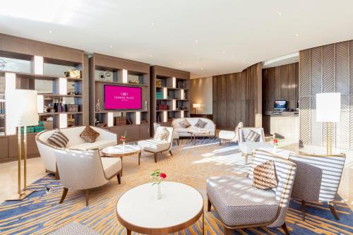 a hotel lobby with chairs and tables and a flat screen tv at Crowne Plaza Vientiane by IHG in Vientiane
