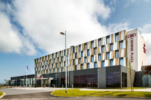 un edificio con un estacionamiento delante de él en Crowne Plaza Aberdeen Airport, an IHG Hotel en Dyce