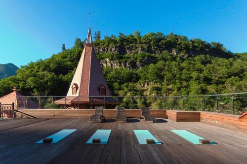 a church with a steeple and benches on a deck at Crowne Plaza - Borjomi by IHG in Borjomi