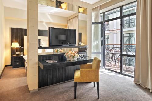 a hotel room with a television and a chair at Crowne Plaza - Borjomi by IHG in Borjomi