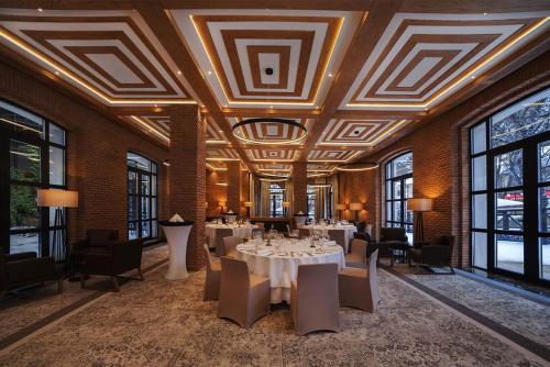 a dining room with tables and chairs and windows at Crowne Plaza - Borjomi by IHG in Borjomi