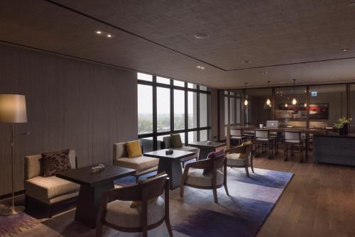 a hotel room with tables and chairs and a bar at Crowne Plaza Tainan by IHG in Tainan