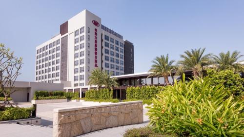 a tall building with palm trees in front of it at Crowne Plaza Tainan by IHG in Tainan
