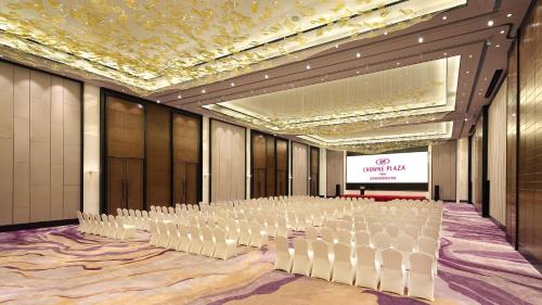 a conference room with white chairs and a screen at Crowne Plaza Yibin by IHG in Yibin