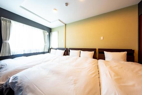 a bedroom with a large white bed with a window at VILLA KOSHIDO KOTONI annex in Sapporo
