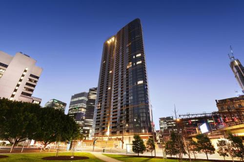 a tall building in a city at night at Orange Stay at Melbourne Quarter in Melbourne