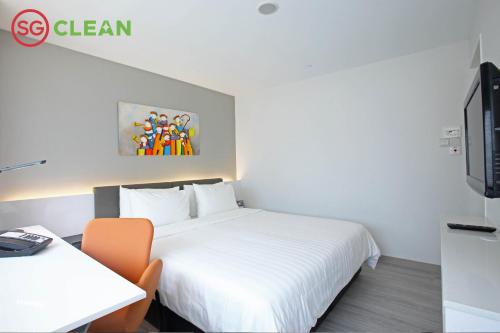 a hotel room with a bed and a desk and a tv at Wilby Central Serviced Apartments in Singapore