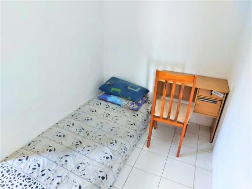 Cette petite chambre comprend un lit, un bureau et une chaise. dans l'établissement Guesthouse Maura, à Pondokcina