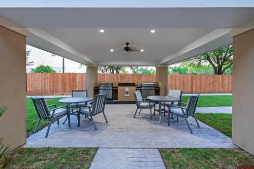 a patio with tables and chairs and a kitchen at Staybridge Suites - Houston IAH Airport East by IHG in Humble