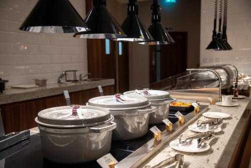 a kitchen with four pots on a stove top at Crowne Plaza London Heathrow T4 by IHG in Hillingdon