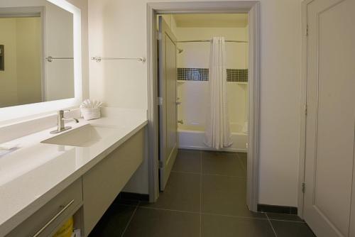 a white bathroom with a sink and a shower at Staybridge Suites - Little Rock - Medical Center, an IHG Hotel in Little Rock