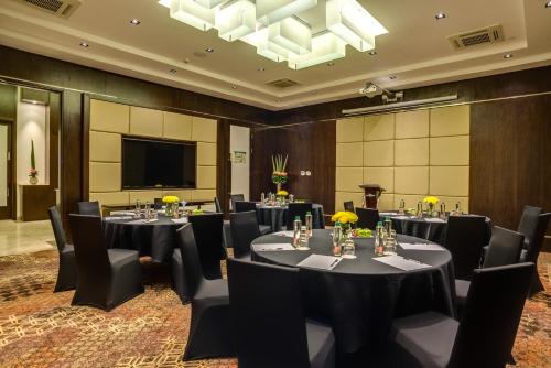 a conference room with tables and chairs and a flat screen tv at Crowne Plaza Nairobi Airport by IHG in Nairobi