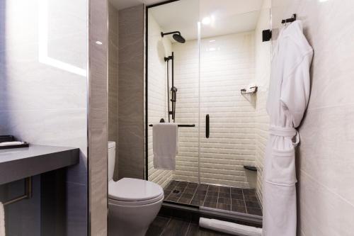 a bathroom with a toilet and a glass shower at Crowne Plaza HY36 Midtown Manhattan by IHG in New York
