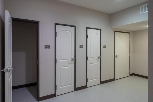 a row of four doors in a room at Staybridge Suites Houston East - Baytown by IHG in Baytown