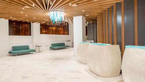 a lobby with green chairs and a chandelier at Crowne Plaza London Kings Cross by IHG in London