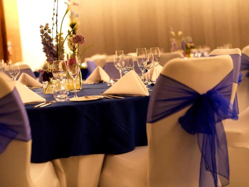 a table with a blue table cloth and chairs with wine glasses at Crowne Plaza London Kings Cross by IHG in London