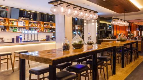 a bar with a long wooden table and chairs at Crowne Plaza London Kings Cross by IHG in London