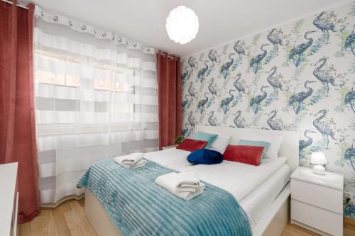 um quarto com 2 camas com almofadas azuis e vermelhas em Sleepway Apartments - Strzelecka 29A-15 em Poznań