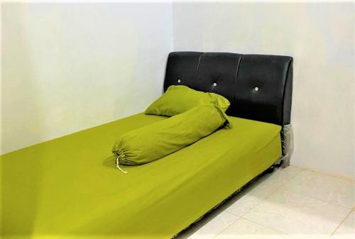 - un lit avec une couverture verte dans l'établissement Radja Guest House, à Balangberu