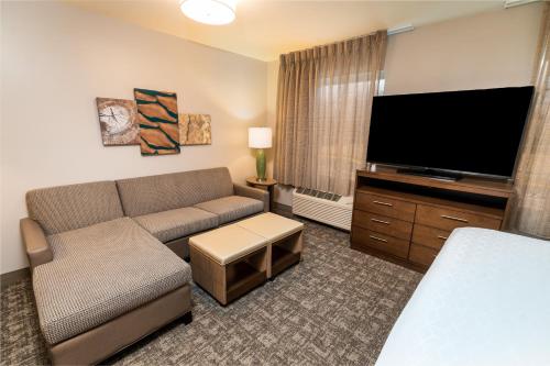 a living room with a couch and a flat screen tv at Staybridge Suites - Washington DC East - Largo by IHG in Largo