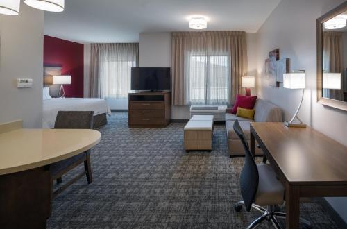 a hotel room with a bed and a living room at Staybridge Suites - Phoenix – Biltmore Area by IHG in Phoenix