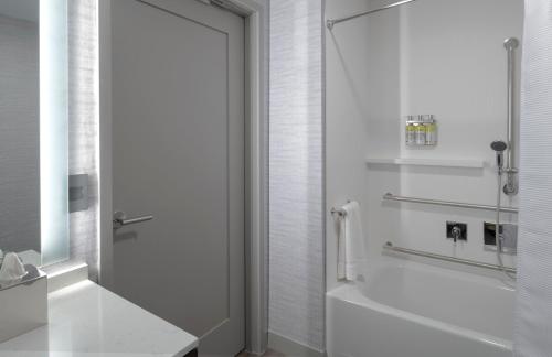 a white bathroom with a shower and a tub at Staybridge Suites - Boston Logan Airport - Revere by IHG in Revere