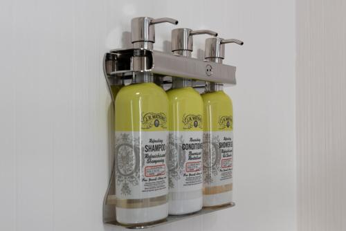 a group of four bottles of liquid sitting on a shelf at Staybridge Suites - Boston Logan Airport - Revere by IHG in Revere