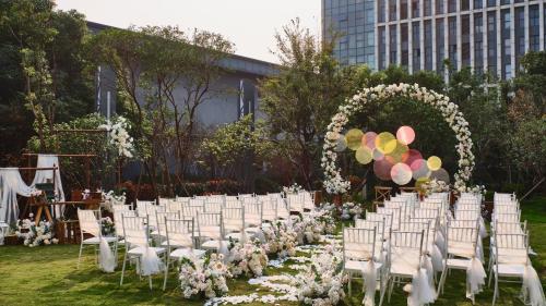 a row of chairs and an arch with flowers and balloons at Crowne Plaza Wuhan Development Zone by IHG in Wuhan