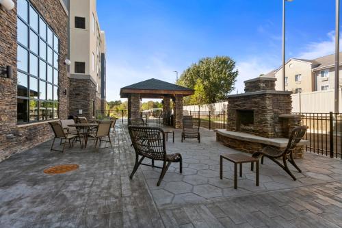 a patio with a stone fireplace and tables and chairs at Staybridge Suites - Atlanta NE - Duluth by IHG in Duluth
