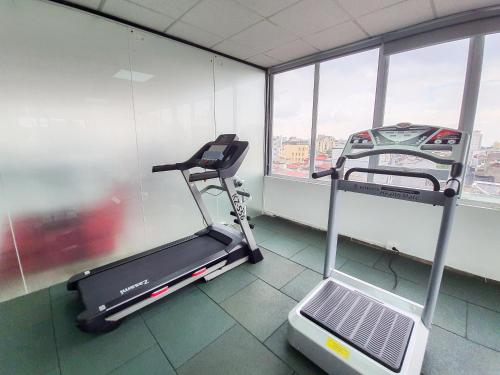 a gym with a treadmill in a room with windows at REIWA INN APARTMENT in Hanoi