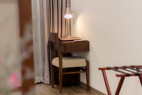 a desk with a chair and a lamp in a room at REIWA INN APARTMENT in Hanoi