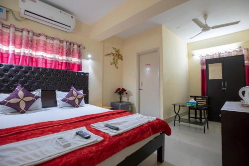 a bedroom with a large bed with a red blanket at The Salvation Army RED SHIELD GUEST HOUSE in Kolkata