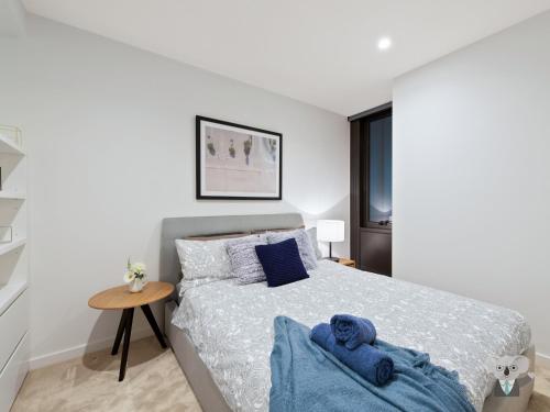 Un dormitorio con una cama con un osito de peluche azul encima. en KOZYGURU MELBOURNE CITY PERFECT TRANQUIL SANCTUARY 1 BED APT VME023, en Melbourne